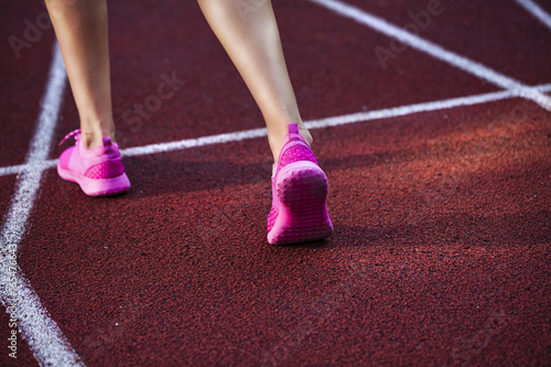 Runner feet running on racetrack closeup on shoe