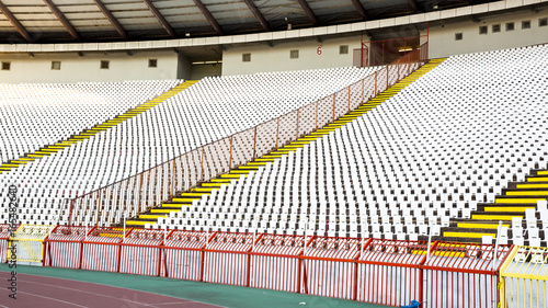 A white seat and a fence with a spear to the stadium