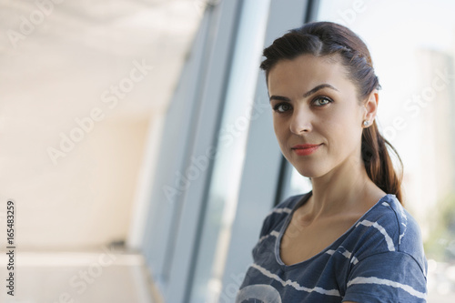 Young woman is waiting at the open space with windows