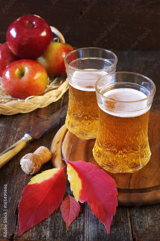 Two glasses of apple cider and red apples Two glasses of apple cider and red apples