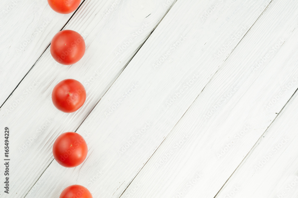 Row of red ripe tomatoes on white rustic wooden background Row of red ripe tomatoes on white rustic wooden background