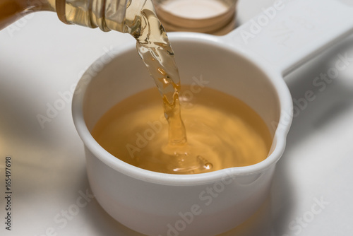 Pouring Apple Cider Vinegar into a Measuring Cup photo