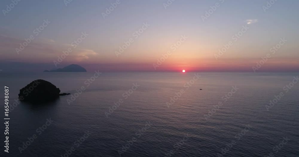 moving side aerial view of mediterranean sea ocean at sunset or sunrise with far islands. Nature outdoors travel establisher, Italy, Sicily Eolian Island. summer or spring.4k drone establishing video moving side aerial view of mediterranean sea ocean at sunset or sunrise with far islands. Nature outdoors travel establisher, Italy, Sicily Eolian Island. summer or spring.4k drone establishing video