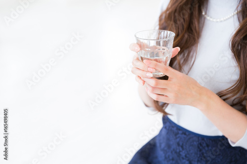部屋で水を飲む女性 手元
