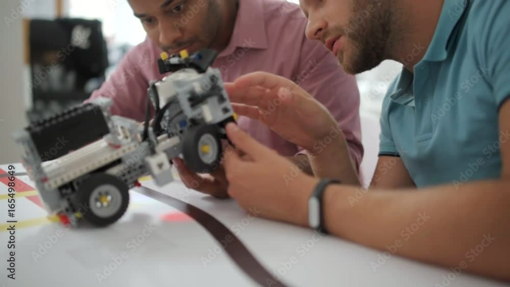 Team of professional discussing robotic machine Team of professional discussing robotic machine