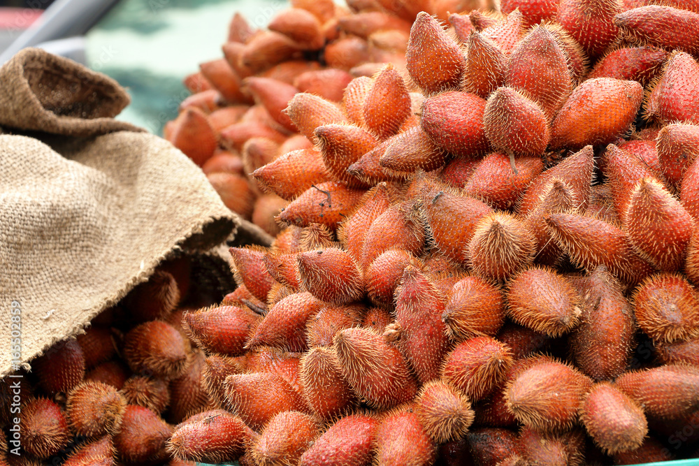 red fresh salacca, zalacca, salak fruit in basket for sale at the fruit market, Thailand.