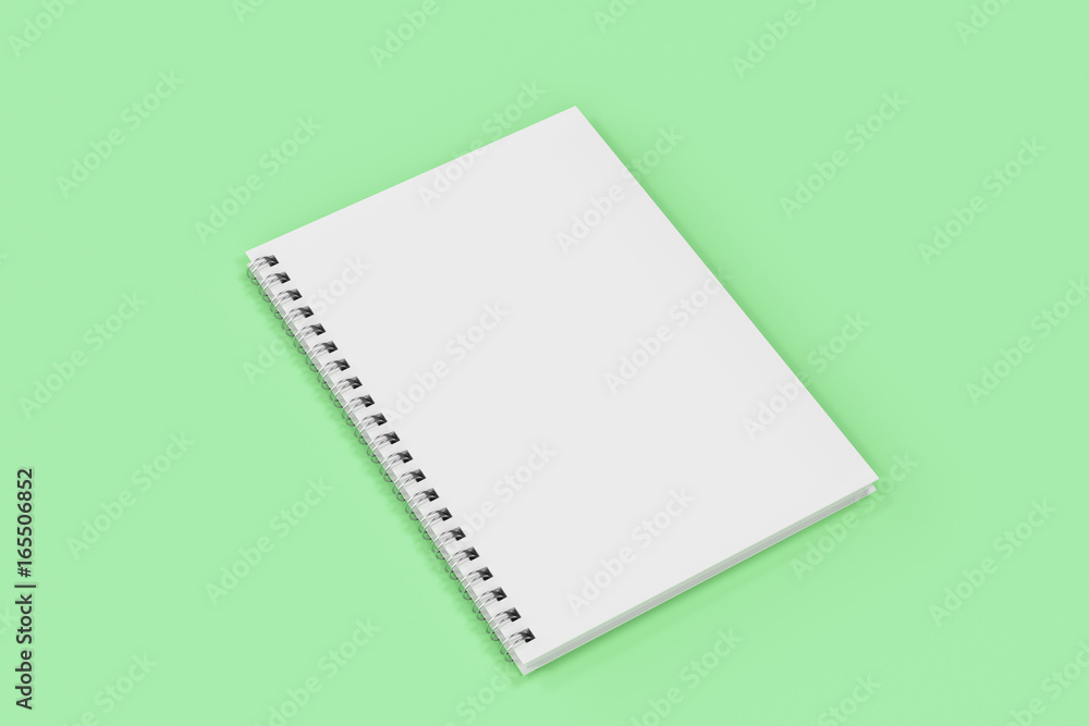 Closed notebook spiral bound on green background Closed notebook spiral bound on green background