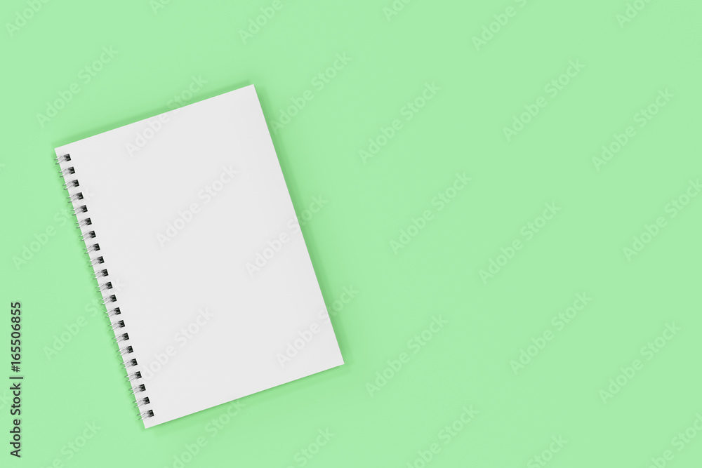 Closed notebook spiral bound on green background Closed notebook spiral bound on green background