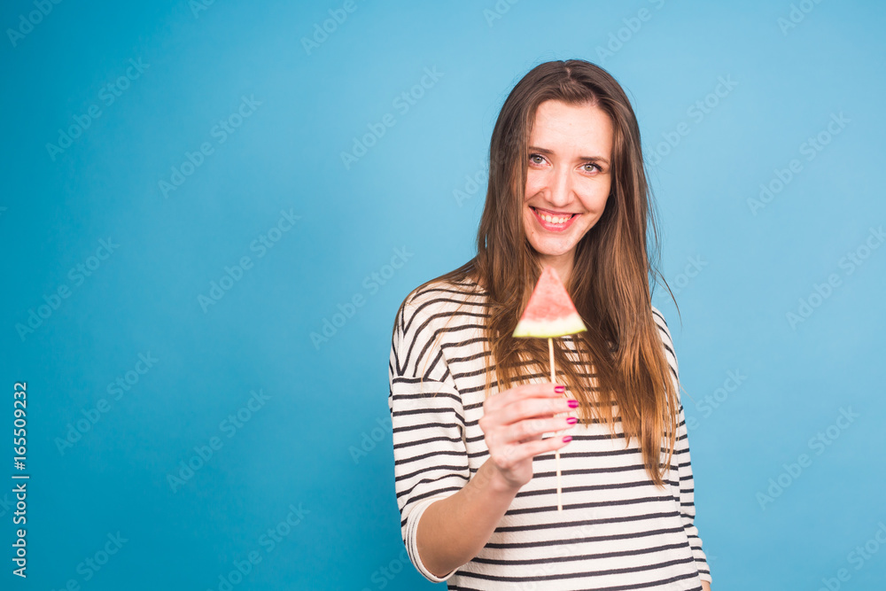 Summer, vacation, diet and vegans concept - Beautiful smiling young woman holding watermelon slice on stick Summer, vacation, diet and vegans concept - Beautiful smiling young woman holding watermelon slice on stick