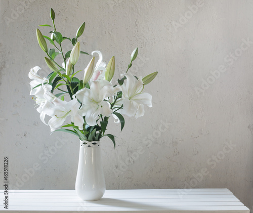 Fototapeta Naklejka Na Ścianę i Meble -  beautiful white lily in vase on background old wall