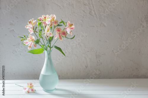 Alstroemeria in vase on grunge white background