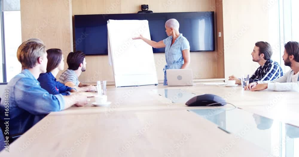 Woman giving presentation to her colleagues in conference room Woman giving presentation to her colleagues in conference room