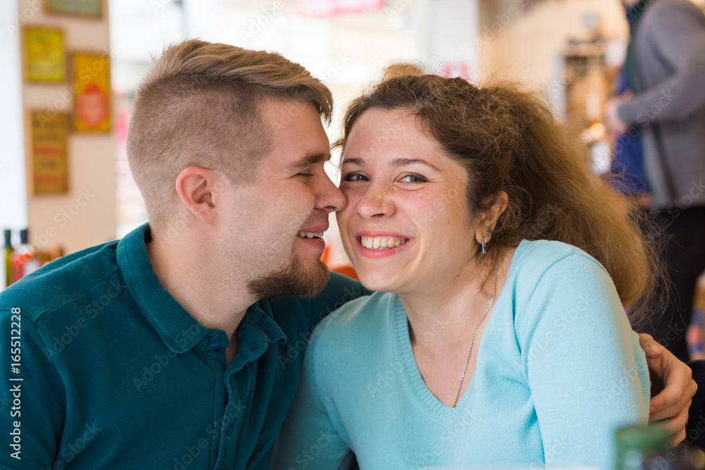 Portrait of beautiful young couple in love at a coffee shop. Gorgeous smiling girl and her boyfriend is laughing Portrait of beautiful young couple in love at a coffee shop. Gorgeous smiling girl and her boyfriend is laughing