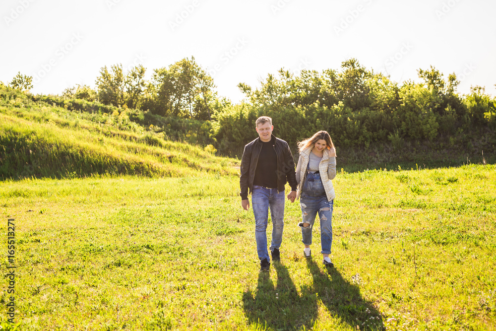 Pregnant woman with husband walking in nature