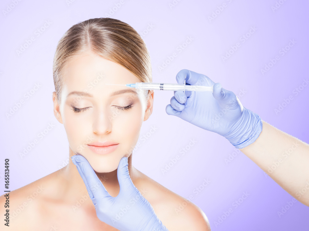 Doctor injecting in a beautiful face of a young woman. Plastic surgery concept. Doctor injecting in a beautiful face of a young woman. Plastic surgery concept.
