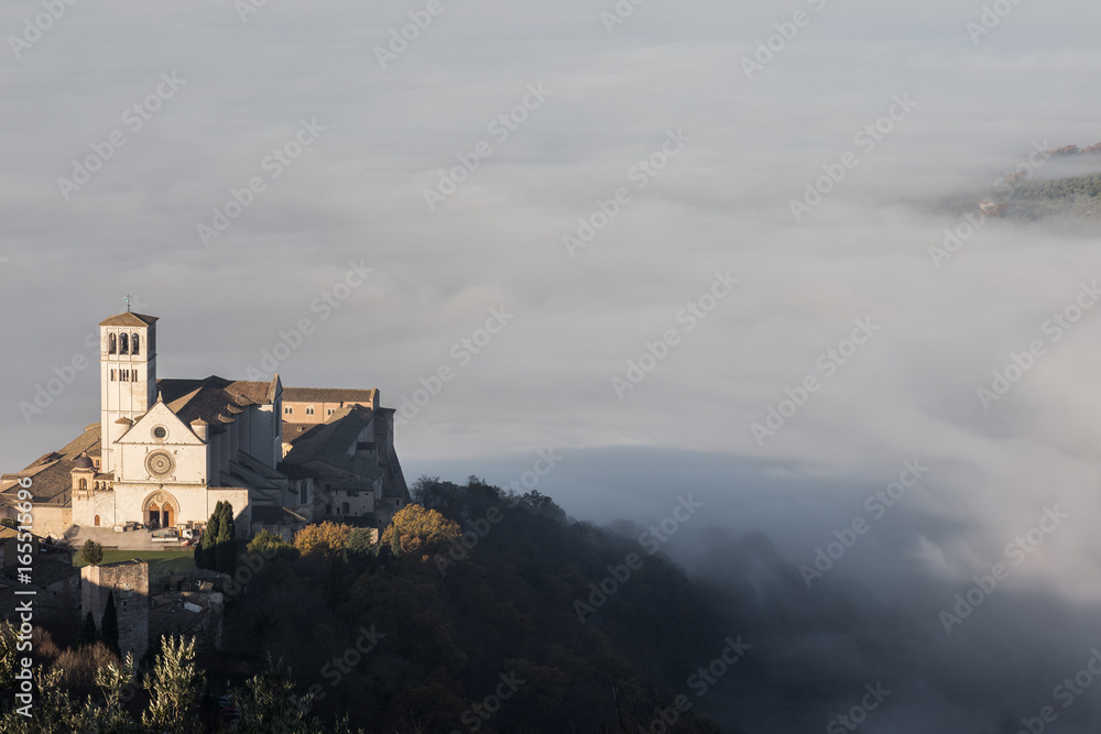 Beautiful view of St.Francis church in Assisi, over a sea of fog