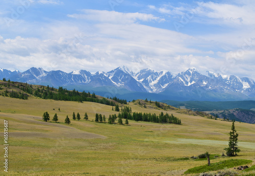 Scenic view of Kurai steppe andwhite peaks of North-Chiyski ridge in Altai mountains in overcast weather. Altay Republic, Siberia, Russia.