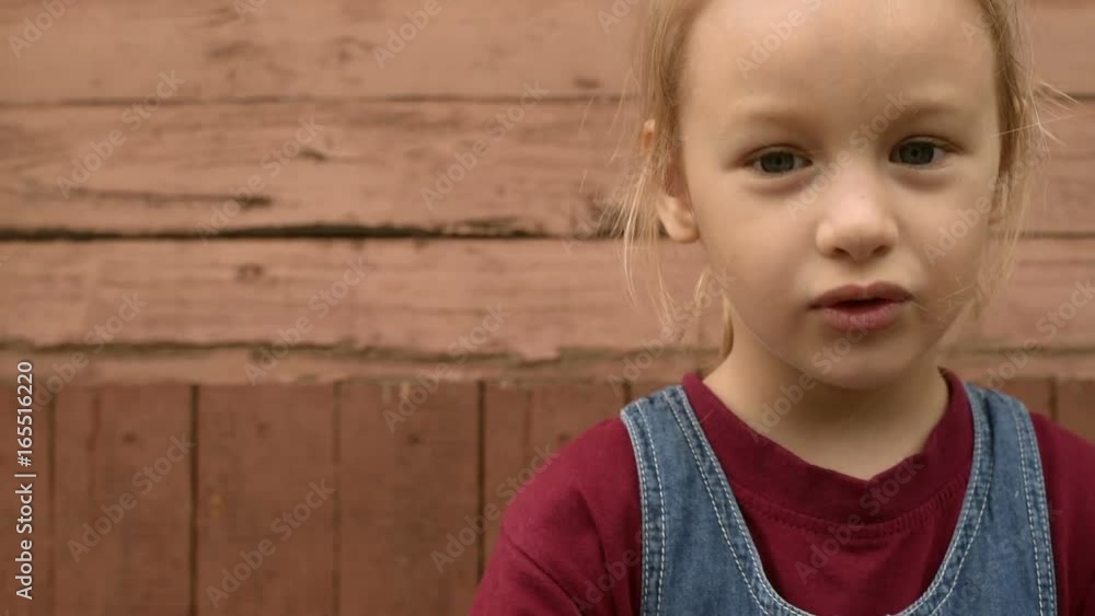 Little girl outdoors on wooden background Little girl outdoors on wooden background