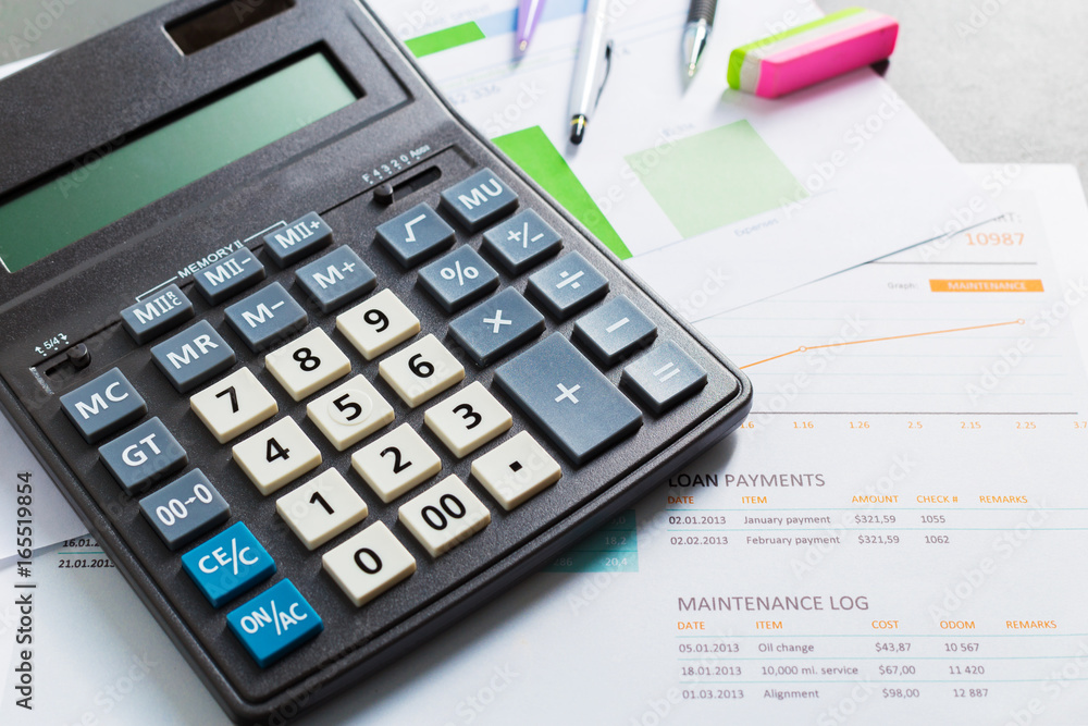 Checking accounting report on business table. Calculator Checking accounting report on business table. Calculator