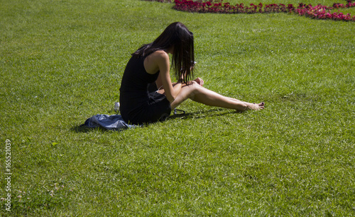 girl sitting on the grass in the Park with phone photo