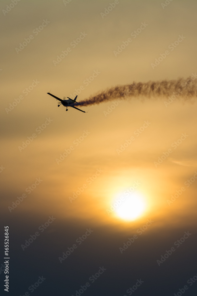 Plane with smoke trail at sunset Plane with smoke trail at sunset