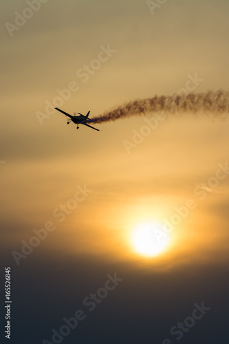 Plane with smoke trail at sunset © mugurel