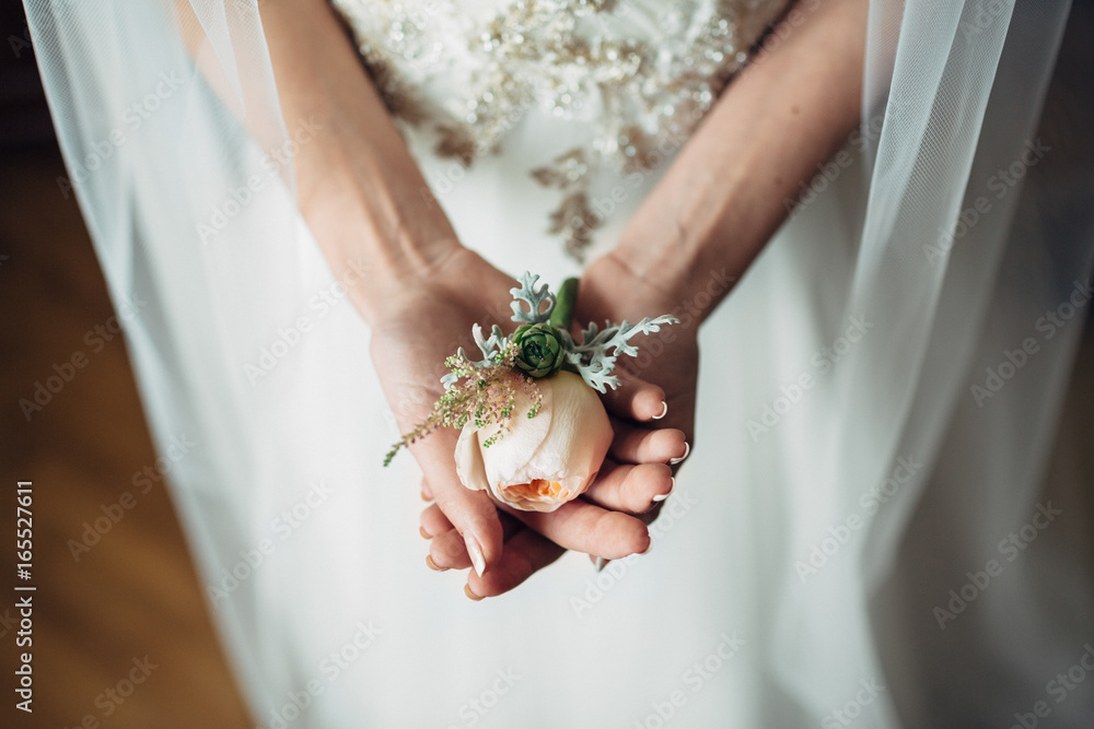 Bride holds tender boutonniere in her arms