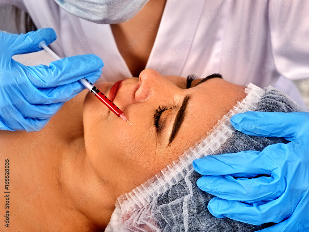 Filler injection female face. Plastic facial surgery in beauty clinic. Eelderly woman of 50-60 years takes care of her appearance number one. Doctor hands with syringe injects. Removal of wrinkles. Filler injection female face. Plastic facial surgery in beauty clinic. Eelderly woman of 50-60 years takes care of her appearance number one. Doctor hands with syringe injects. Removal of wrinkles.