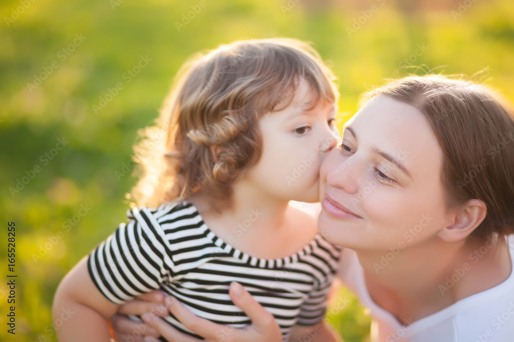 Cute toodler girl kisses her youang mother