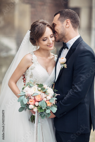 Classy wedding couple poses on the old European street