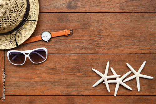 Summer straw hat and starfish on wooden background
