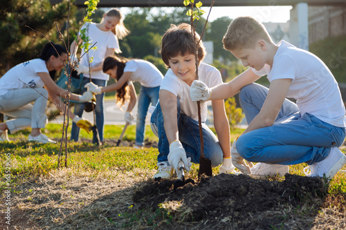 Schilderij op canvas Schoolchildren planting young fruit trees