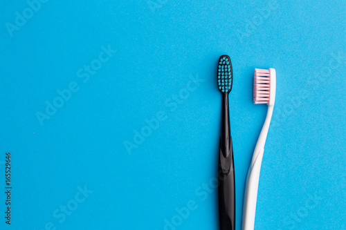 Black  pink toothbrushes on blue