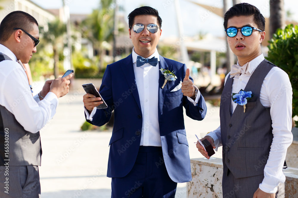 Groom and groomsmen in sunglasses pose outside Stock Photo | Adobe Stock