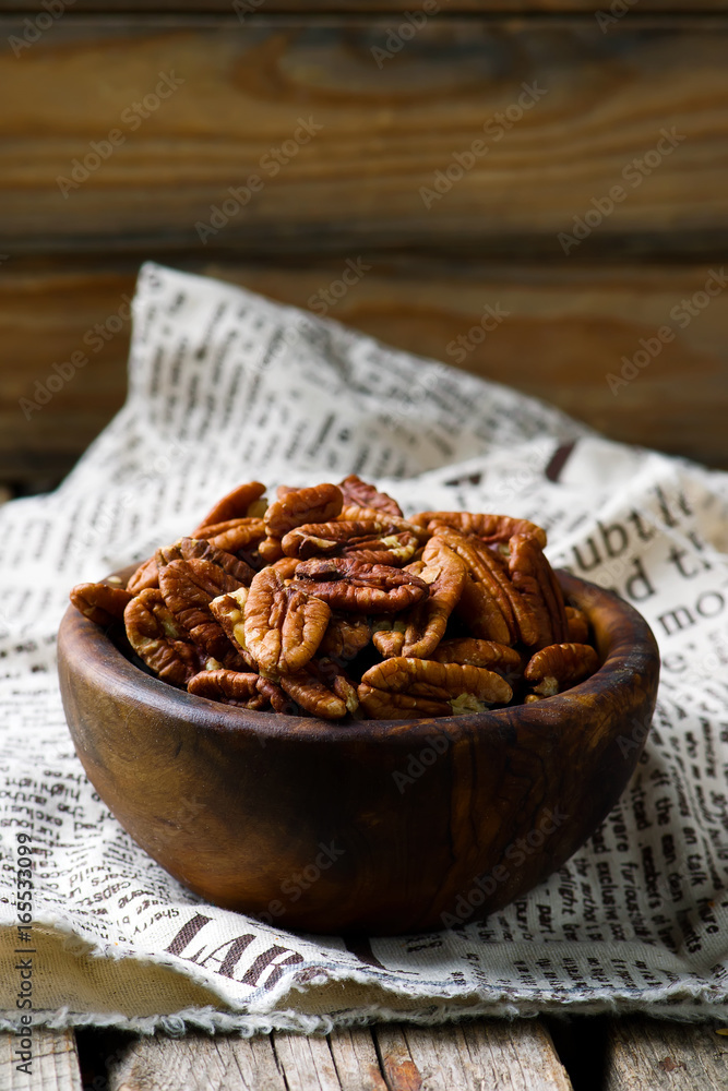 a pecan is in a wooden bowl. style rustic