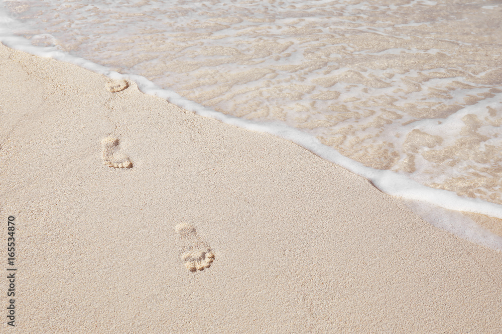 Human footprints on beach sand at resort Human footprints on beach sand at resort