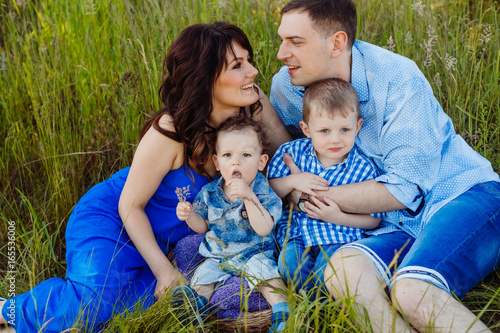 Parents sit with their little sons on the field photo