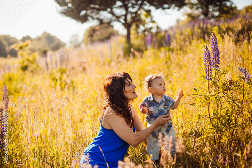 Little boy walks with his mom on the field