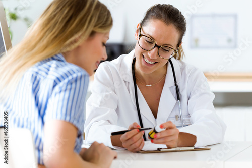 Female doctor prescribing medication for patient.