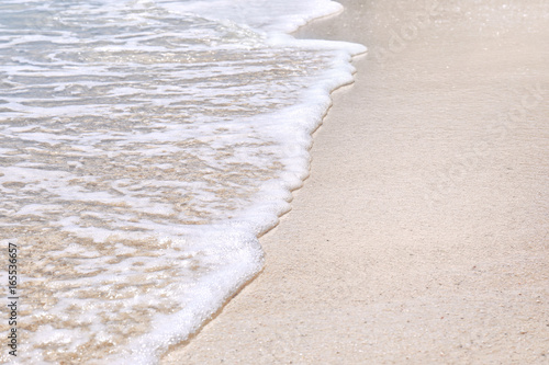 Warm sand and sea waves on beach at resort, closeup