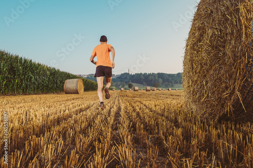 Uomo che corre in un campo di grano in campagna
