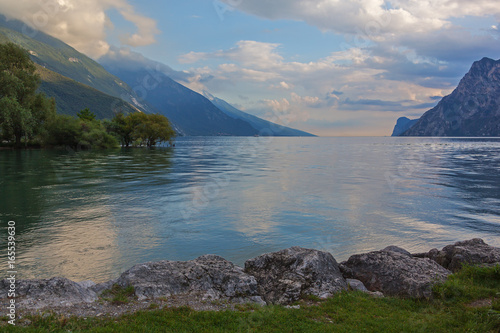 Picturesque view of the gorgeous mountain Garda Lake from Riva del Garda side by evening, Italy