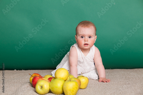 baby girl in a dress with Green apples photo