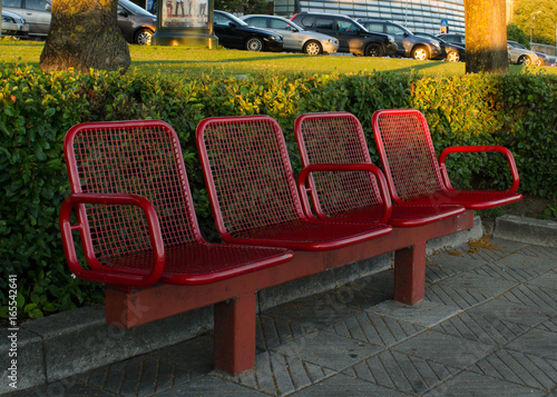Red painted steel bench in the city.  © Jeena