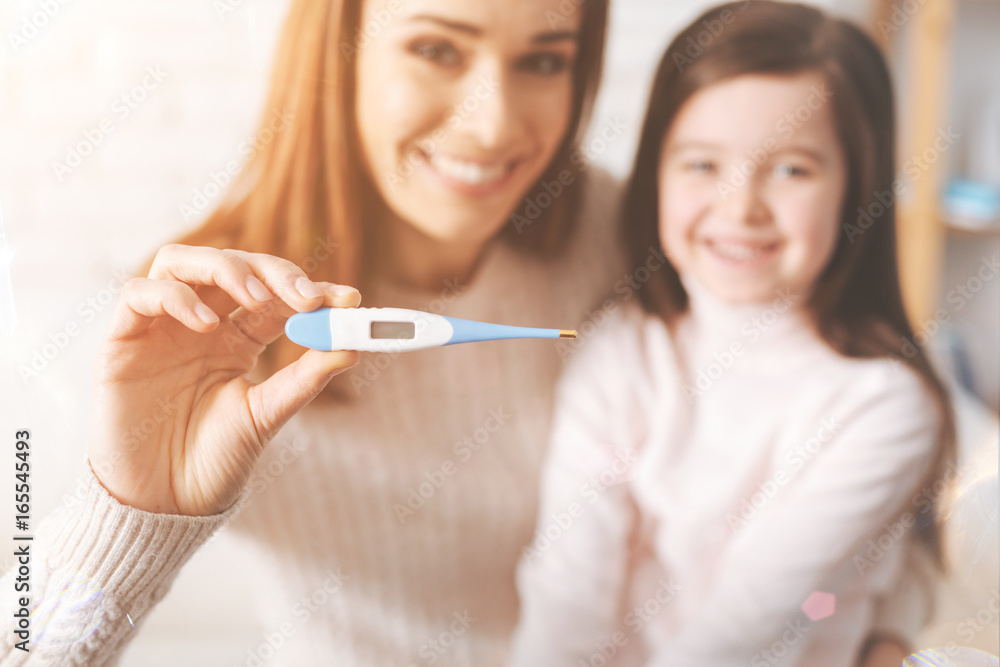 Positive delighted woman demonstrating new thermometer Positive delighted woman demonstrating new thermometer