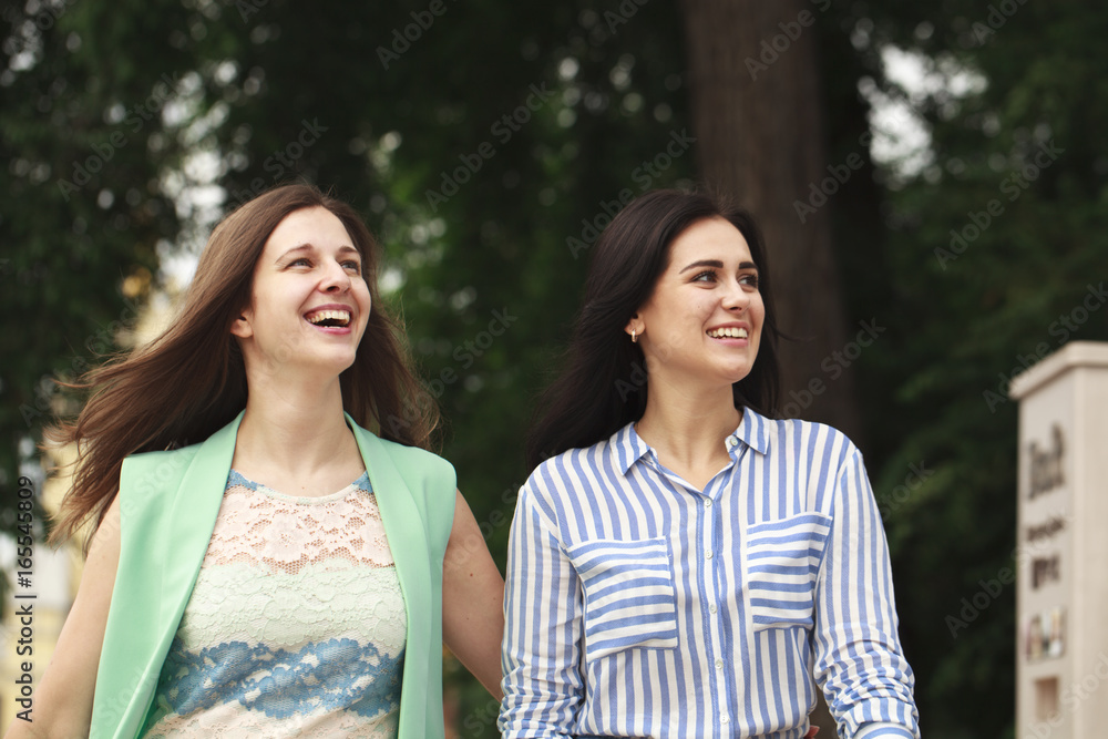 Two happy women walking in the summer park Two happy women walking in the summer park