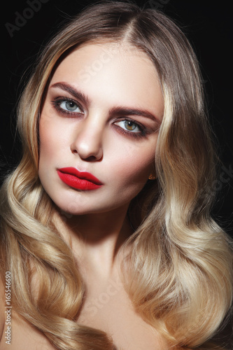 Young beautiful glamorous woman with red lipstick and blonde curly hair