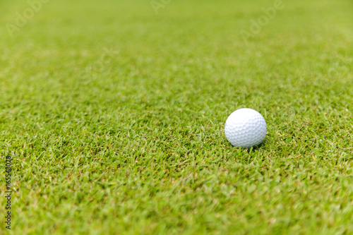 Golf ball on green grass on golf course