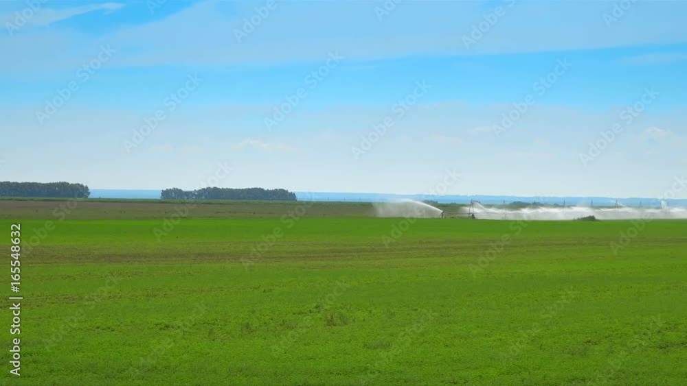 Watering of an agriculture. Fields, big on the area, pour down autowatering. Plants on a farm pour down autowatering Watering of an agriculture. Fields, big on the area, pour down autowatering. Plants on a farm pour down autowatering
