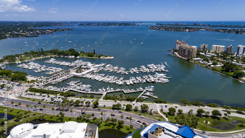 Drone view looking out from downtown Sarasota towards Big Sarasota Pass with Marina Jack, Bayfront Park and Golden Gate in the foreground.